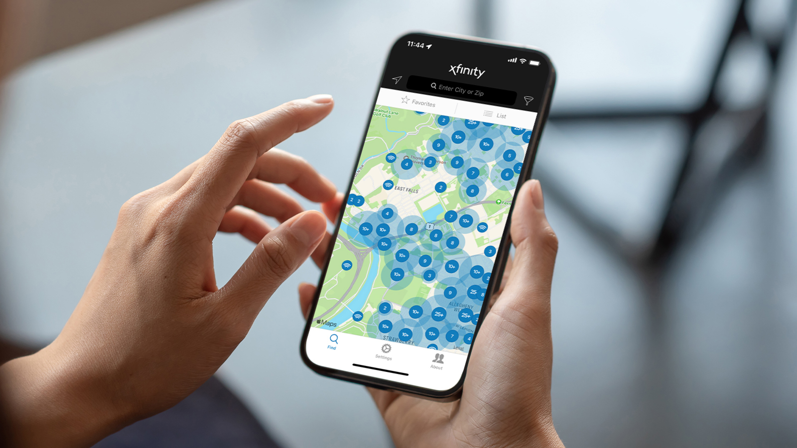 Close up of hands holding smartphone showing Xfinity hotspots.